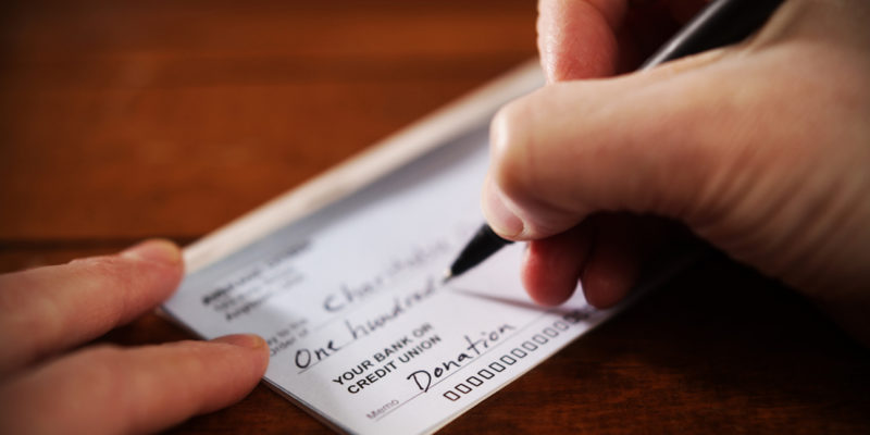 up close image of a check being written with a black pen