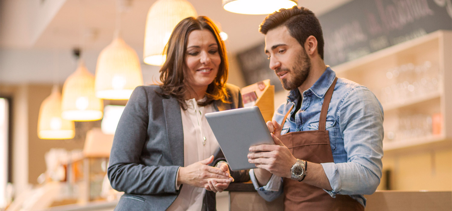 small business owner reviewing a tablet with a professional woman